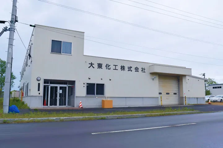 白い外壁に「大東化工株式会社」の社名が掲げられた工場建物
